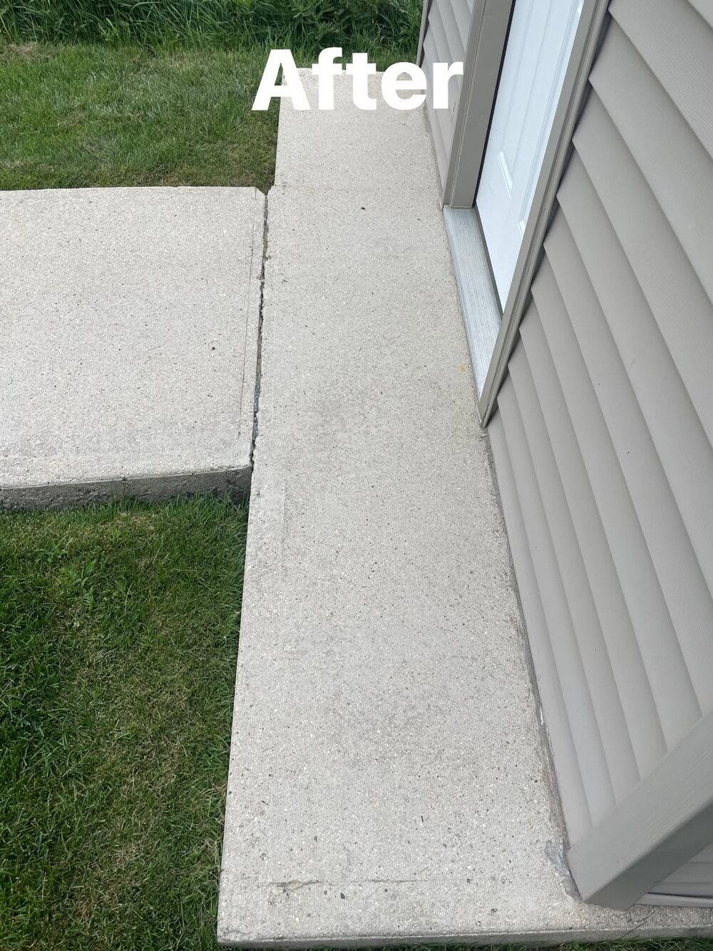 A cleaned concrete step and walkway running alongside a shed, bright and even after washing