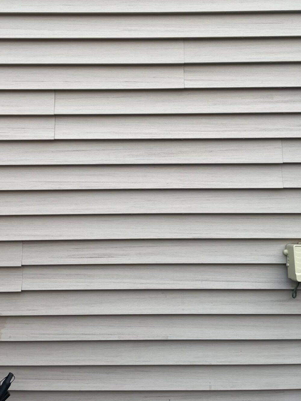 The same siding washed clean back to even grey
