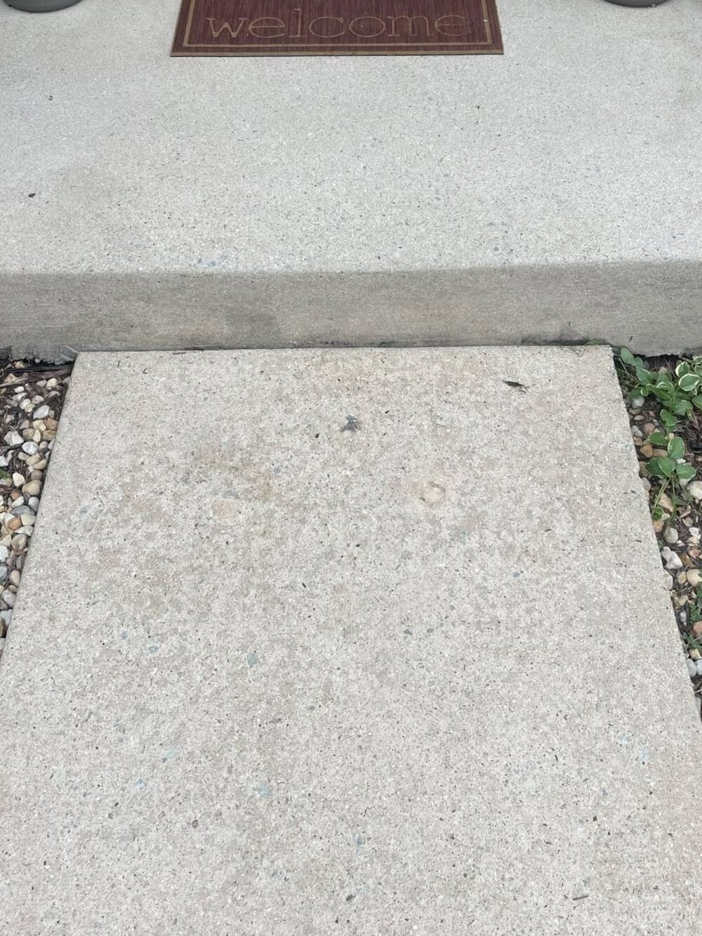 The same front stoop after cleaning, the concrete bright and even